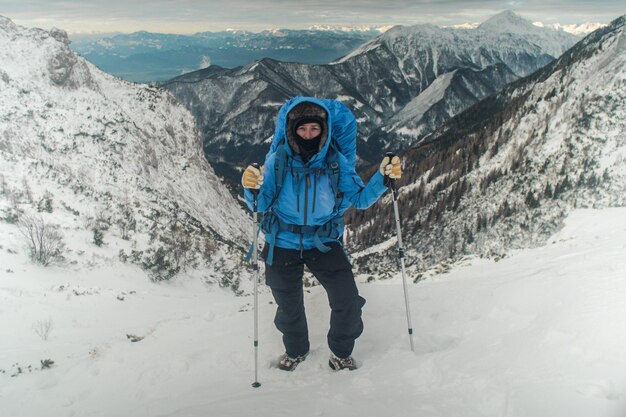 写真 空に向かって雪で覆われた山を登る女性