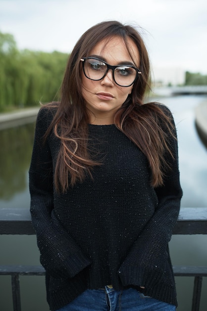Женщина-хипстер в очках на мосту летом в городе Концепция образа жизни и моды