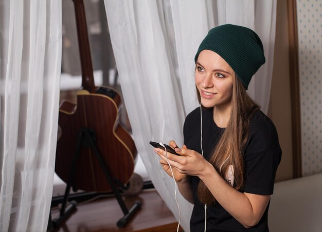 Woman hipster in green hat listening music and enjoying life