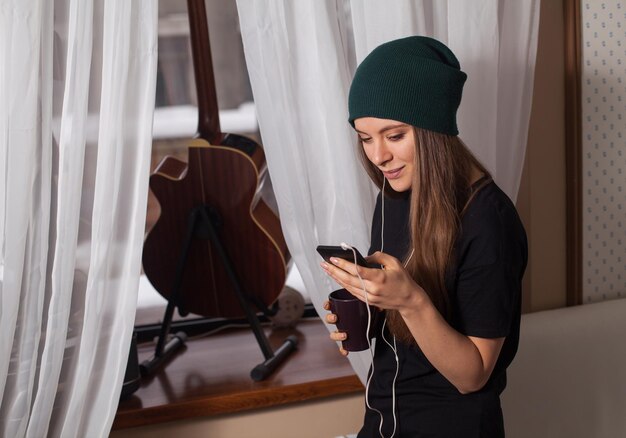 Woman hipster in green hat listening music and enjoying life