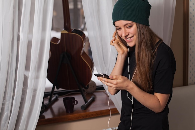 Woman hipster in green hat listening music and enjoying life