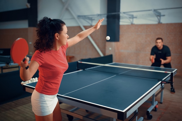 Woman hits the ball playing table tennis