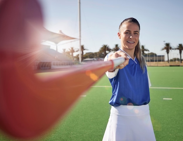 Photo woman hockey player closeup and portrait on field with smile hockey stick and happy in sunshine hockey outdoor and sport girl at training exercise and workout in sports ground arena or stadium