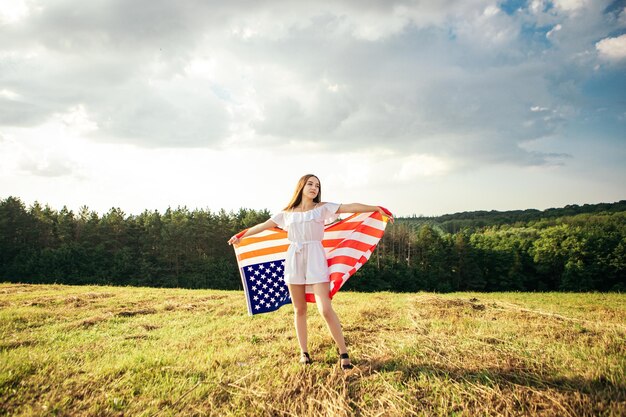 女性はアメリカの国旗を保持します