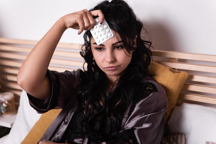 女性は白い薬の錠剤のブリスターパックを保持します