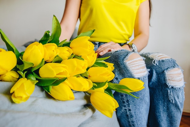 woman hold bouquet of yellow tulips romantic flowers knees wide