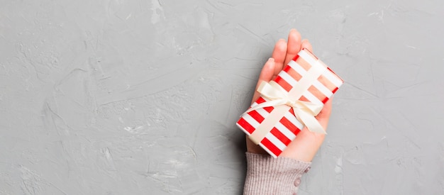 Woman hold Christmas gift box on colorful background