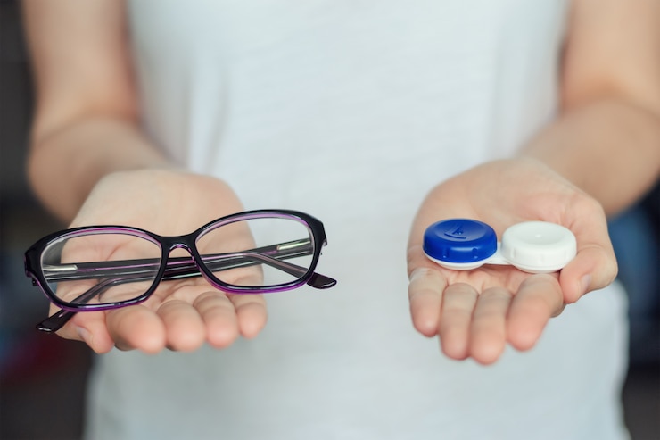 Photo woman hold contact lenses and glasses in hands. concept of choice of vision protection