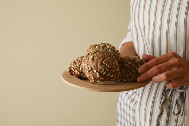 Woman hold fresh baked buns with sunflower seeds