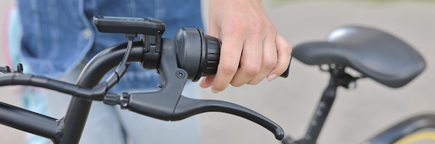 Woman hold handlebars of bicycle close up.