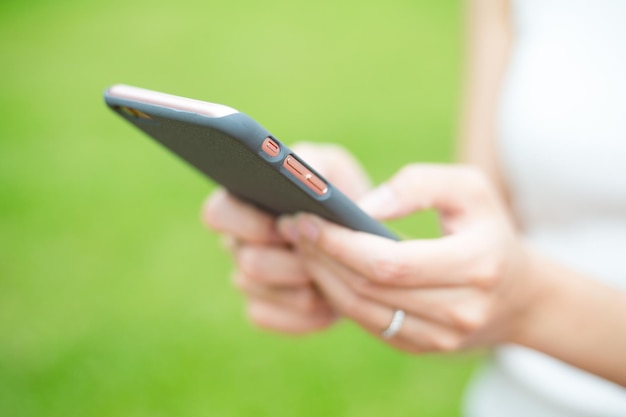 Woman hold a mobile phone over green plant background