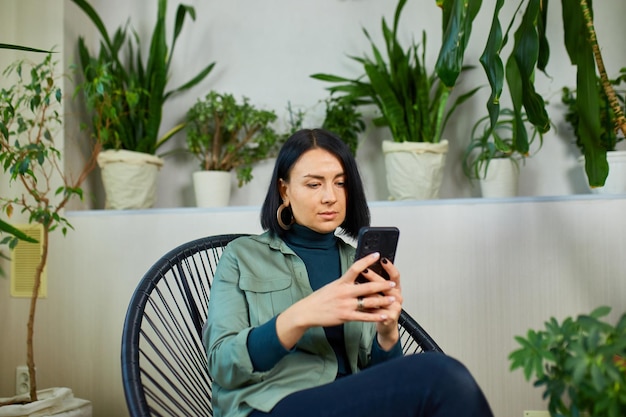 女性は携帯電話とサーフィン インターネット タイプのメッセージを保持します。