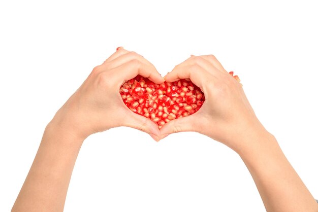 Woman hold pomegranate seeds. Heart symbol, isolated on white.