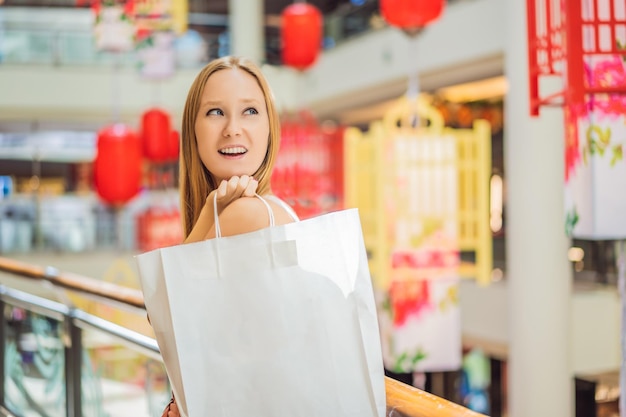 중국 새해 큰 중국 붉은 등불의 배경에 쇼핑백을 들고 여자