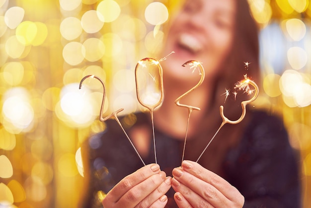 Woman holding 2023 sparklers at new year eve