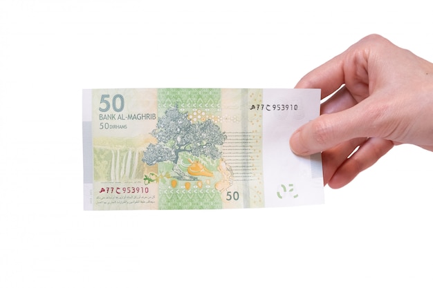 Woman holding a 50 Moroccon Dirham banknote in her hand on a white 