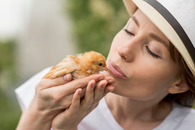 写真 農場でひよこを保持している女性