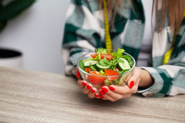 Фото Женщина держит в руках салат для здорового образа жизни