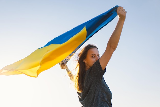 写真 屋外でウクライナの黄色と青の旗を保持している女性