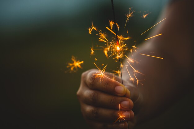 사진 일몰 시간에 쌀 필드에서 축제에 불 폭죽을 들고 노는 여자