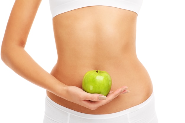 woman holding an apple over her belly