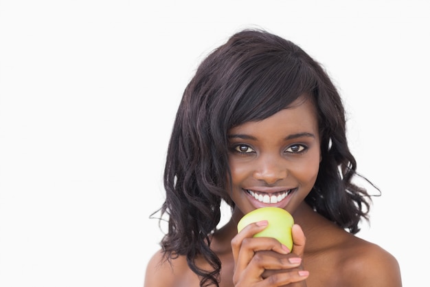 Woman holding an apple while smiling 