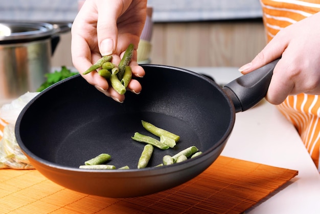 Woman holding asparagus on kitchen close up