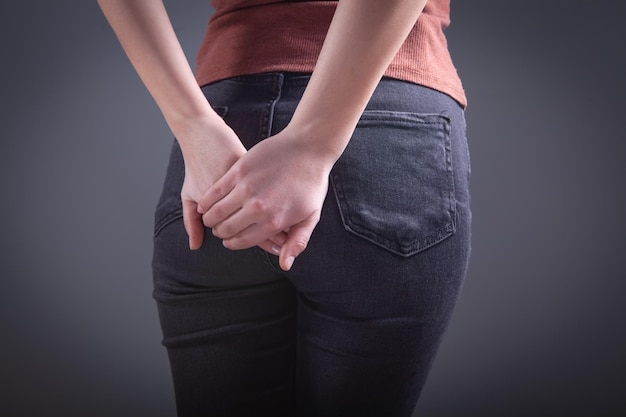 Woman holding ass hemorrhoids concept