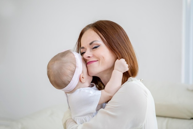 Foto donna che tiene in braccio una bambina a casa