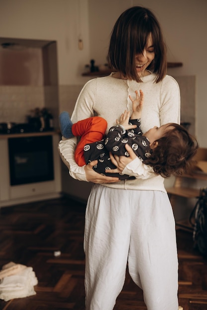 A woman holding a baby in her arms in a kitchen