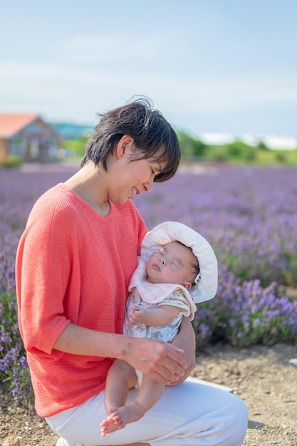 A woman holding a baby in a lavender field