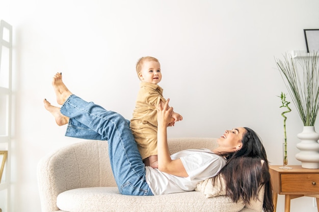 Woman holding baby on top of couch