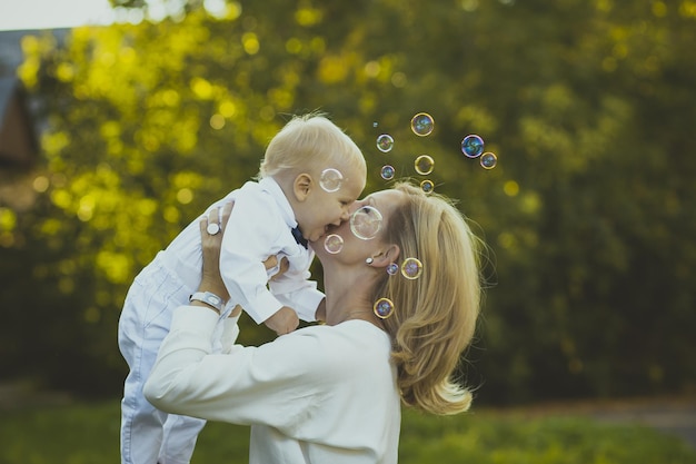 A woman holding a baby and a woman holding bubbles in the air