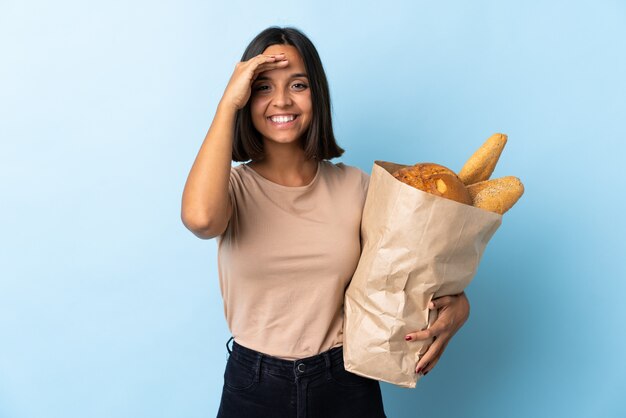 Woman holding a bag full of bread