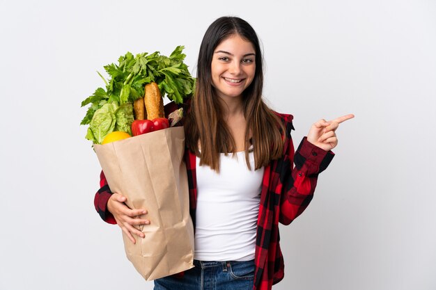 野菜がいっぱい入った袋を保持している女性