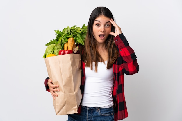 野菜がいっぱい入った袋を保持している女性