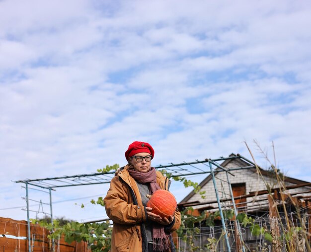 Photo a woman holding a ball in front of a house