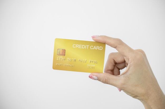 Woman holding bank business credit card on white background
female hand holding bank credit card gold paying using credit card
shopping lifestyle copy space