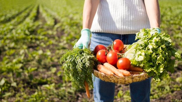 Woman holding a basket full of vegetables with copy space