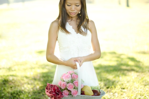 Photo woman holding basket while standing on field