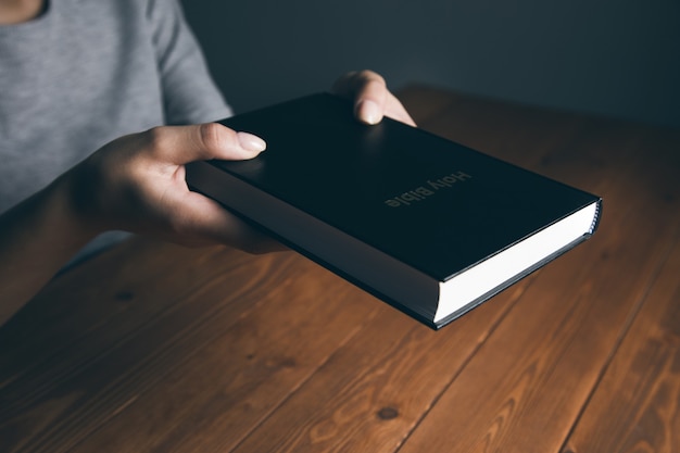 Woman holding bible at table