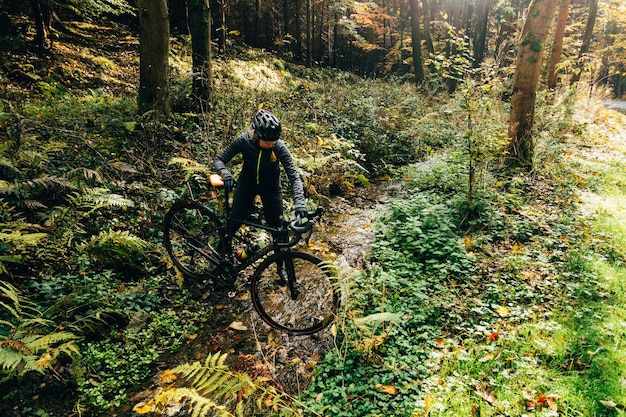 woman holding bicycle in forest