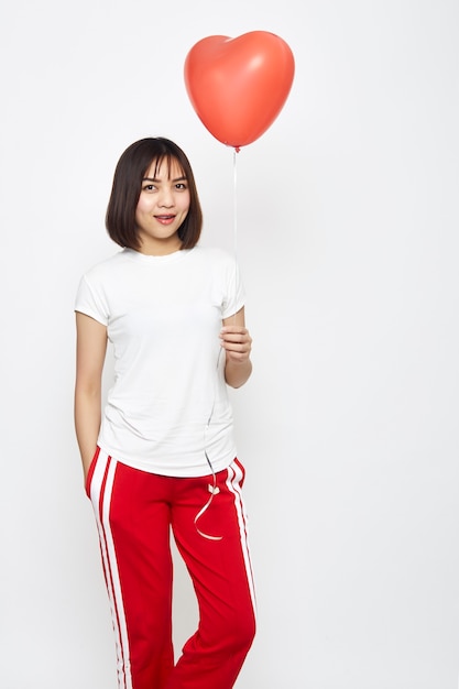 Woman holding big red balloon heart 