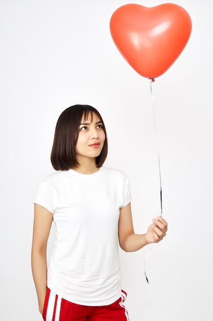 Woman holding big red balloon heart 