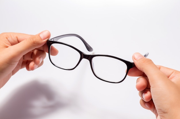 Woman holding the black eye glasses spectacles with shiny black frame isolated on white