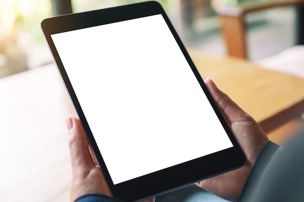 a woman holding black tablet pc with blank white desktop screen