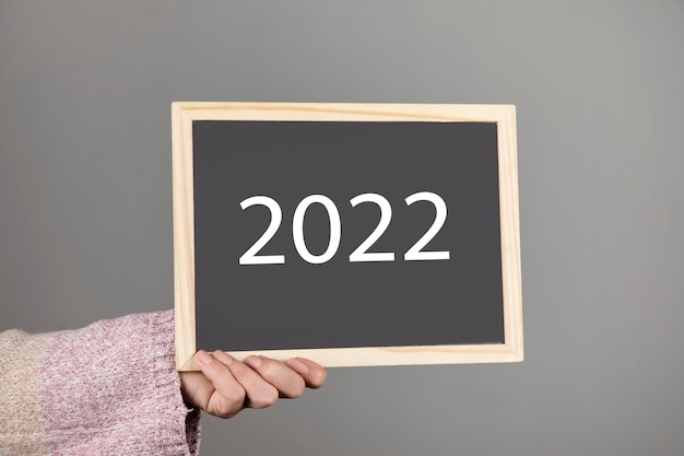 Woman holding blackboard with 2022