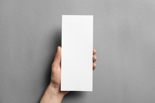 Woman holding blank card on grey background Mock up for design