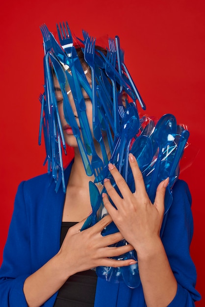 Photo woman holding blue plastic tableware