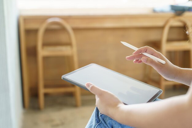 Woman holding a book device reading on ebook on digital tablet device or social media apps online ecommerce